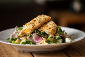 Garlic and herb–crusted local mahi-mahi and Middle Eastern fattoush salad. Photography by Benjamin Rusnak