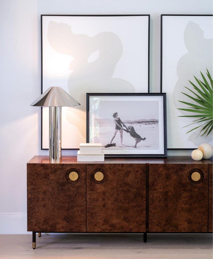 This mid-century modern buffet (Jon’s personal favorite style era) grounds a busy pass-through between the dining room and the kitchen. A stainless steel lamp and layered art pieces top off the clean aesthetic. Photo by Jerry Rabinowitz